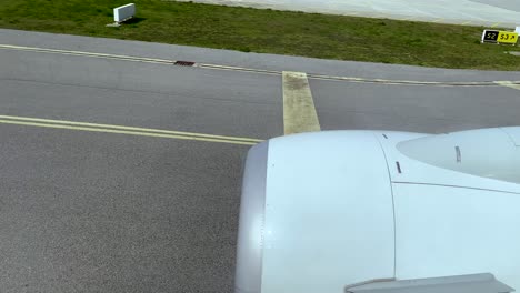 pov airplane window view showing runway of airport after landing during daytime