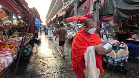 monk walking through a market, collecting alms