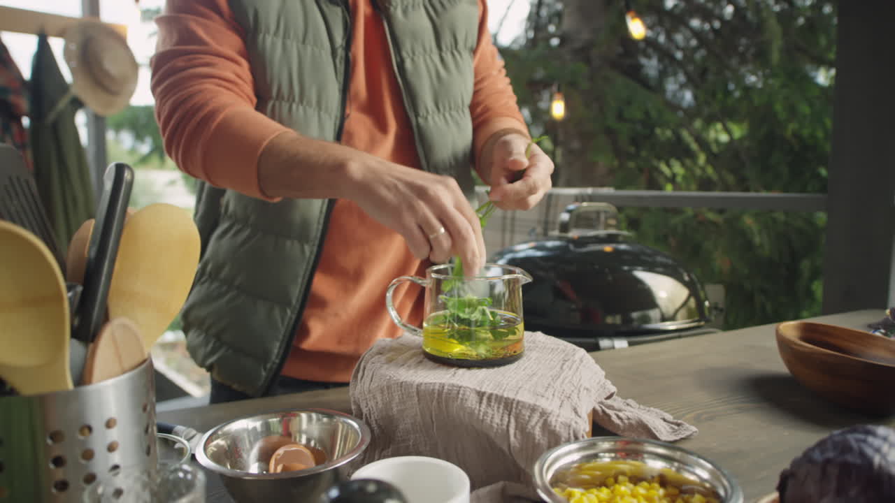 Man Preparing Herbal Tea on Outdoor Terrace