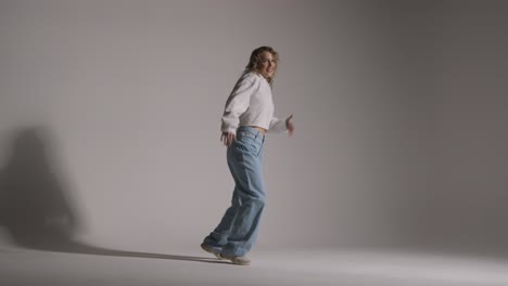 Full-Length-Studio-Shot-Of-Young-Woman-Having-Fun-Dancing-Against-Grey-Background-1