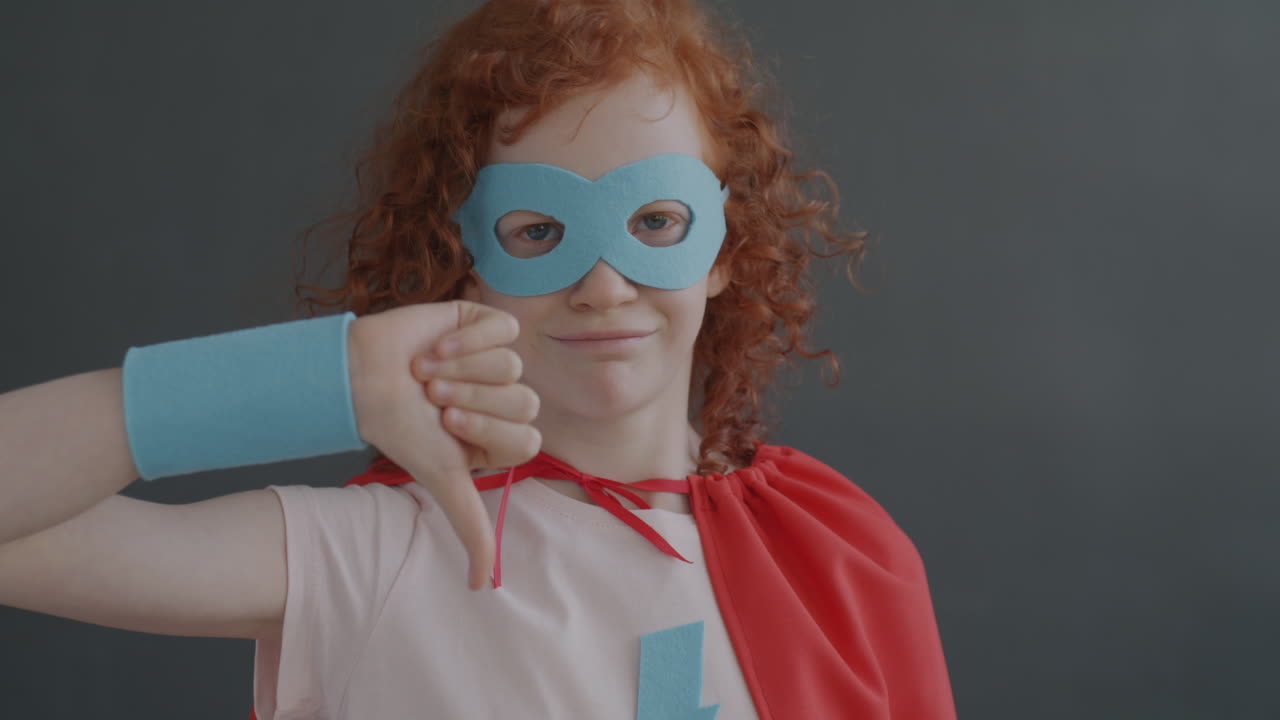 Child in Superhero Costume Giving Thumbs Down