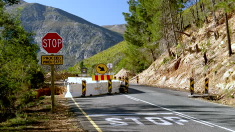 stop sign and road block on a mountain road