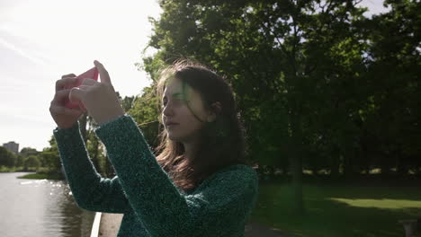 bonita mujer italiana turista tomando fotografías de un parque en wimbledon londres