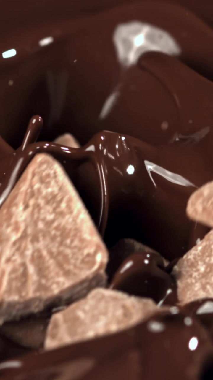 Gerak Lambat Potongan Cokelat Memercik ke Dalam Cokelat Leleh