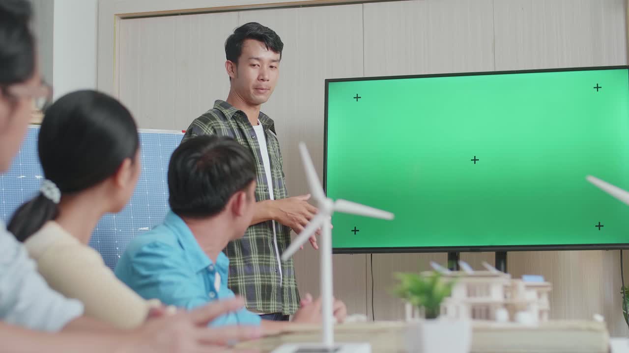 사무실에서 녹색 스크린 tv에 대해 발표하는 태양 셀을 가진 아시아 남자 엔지니어