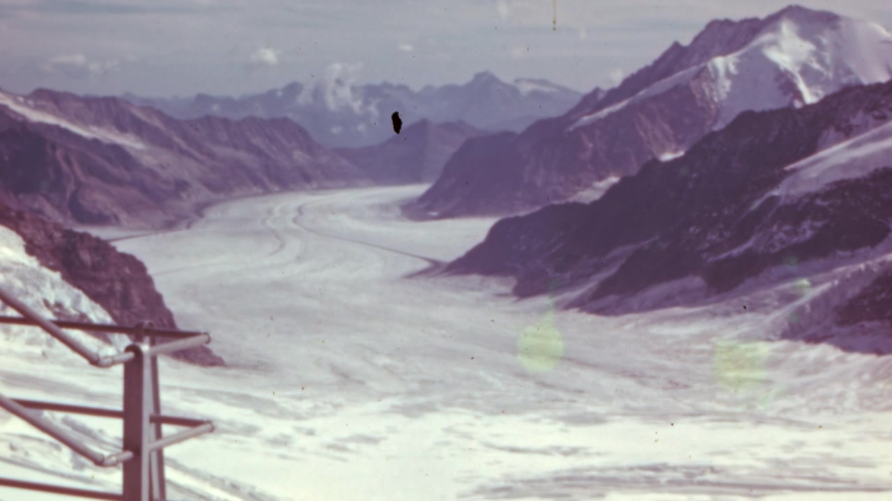 Montagna innevata e ghiacciaio visti da un punto panoramico elevato nella regione della Jungfrau, Oberland Bernese, Svizzera. Cattura il ghiacciaio incontaminato prima degli effetti del riscaldamento globale. Filmato d'archivio a colori in 4K