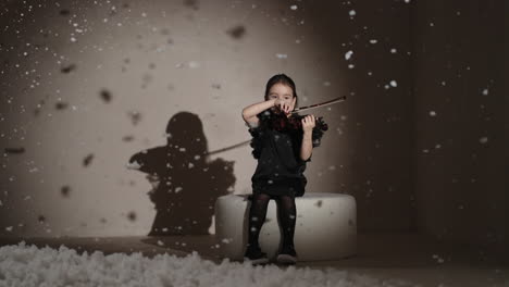 young girl playing violin in a winter studio setting