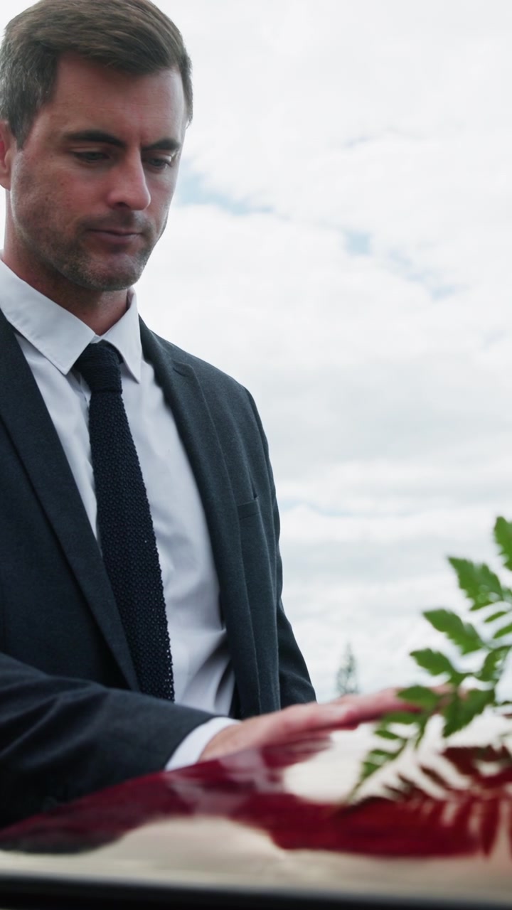 Uomo in giacca e cravatta che rende omaggio a un funerale