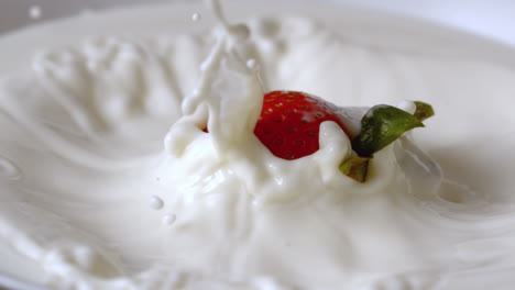 la fraise tombe dans un verre de lait