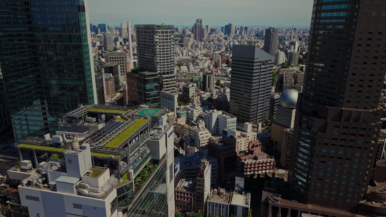 Aerial view of a cityscape with skyscrapers and rooftop helipad