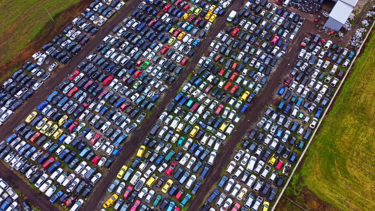 Ampio parcheggio pieno di molti veicoli in sosta in un'area rurale durante il giorno.