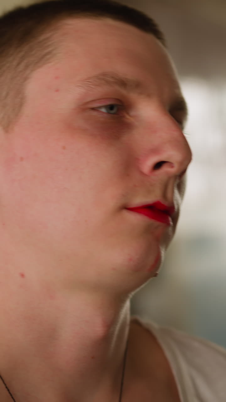 Special forces officer takes mask off terrorist head while blood pours from man mouth in abandoned building hall close view slow motion