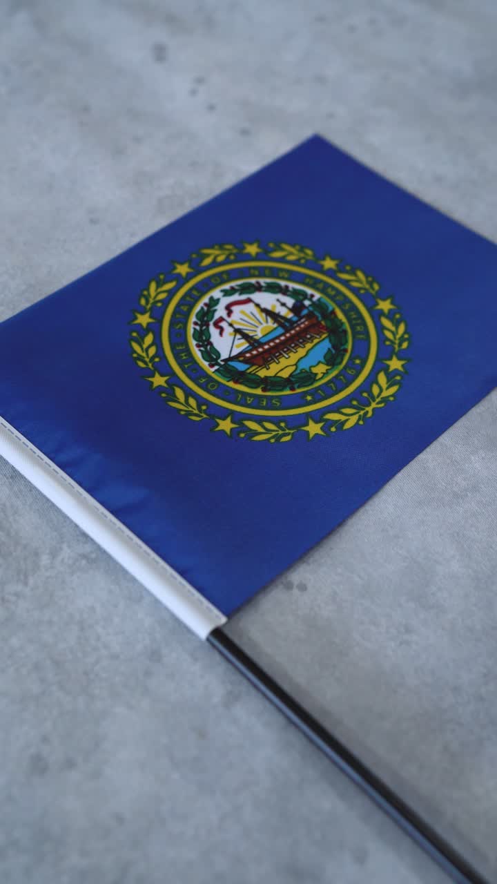 Státní vlajka New Hampshire na šedém pozadí. Vertikální záběr