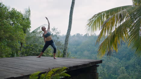 yoga woman practicing lord of the dance pose outdoors in tropical jungle enjoying mindfulness exercise 4k