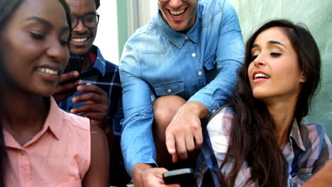 retrato de jóvenes hipsters mirando un teléfono inteligente y riendo