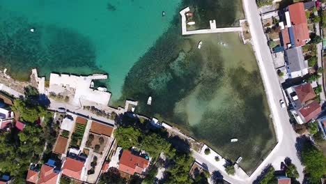 AERIAL---Flight-with-the-DJI-Phantom-4-on-summer-holiday-directly-at-the-holiday-home-over-the-deep-blue-Adriatic-Sea-and-part-of-the-village-Zdrelac-on-the-island-of-Pasman-in-Croatia