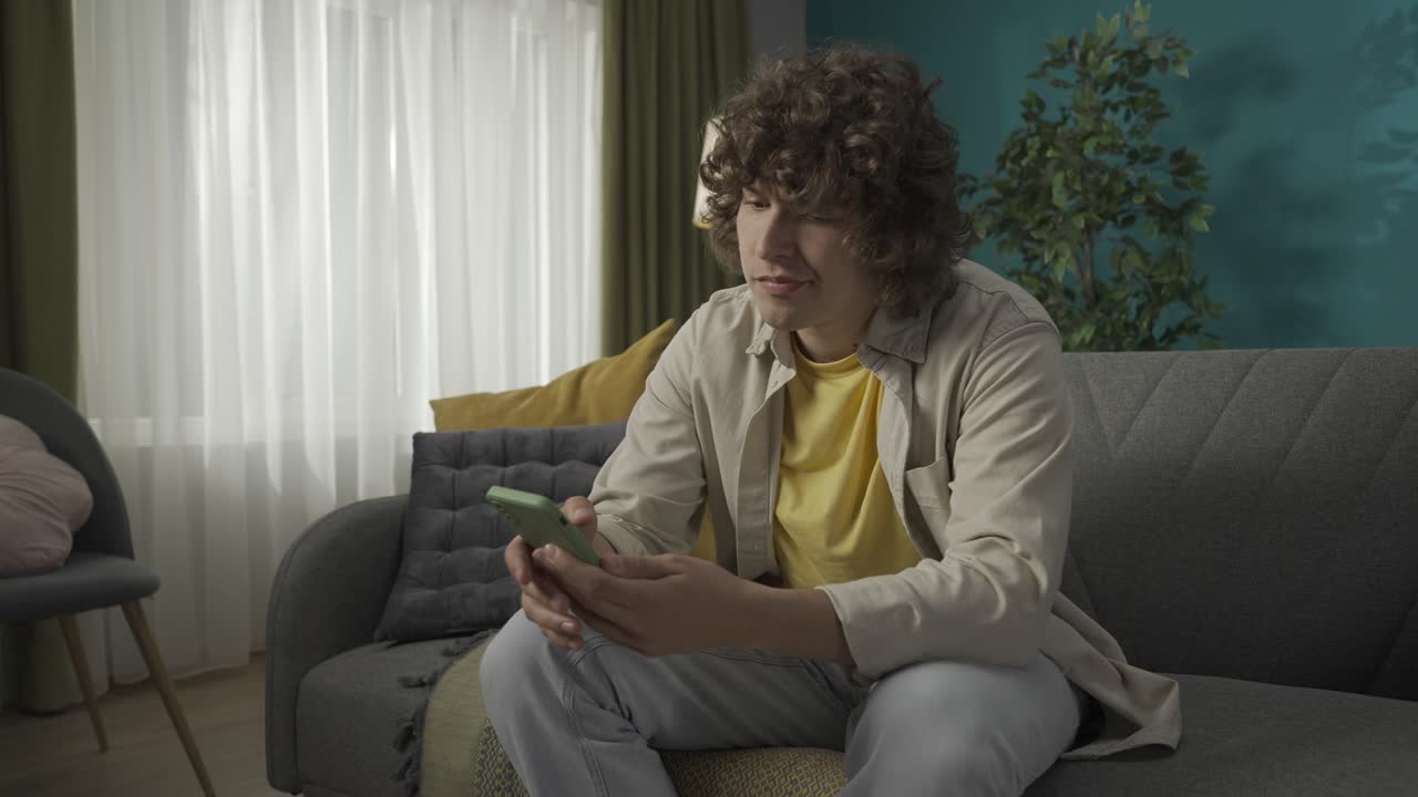 Teenager using a smartphone on a couch