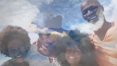 Animation-Einer-Glücklichen-Afroamerikanischen-Familie,-Die-Sich-Am-Strand-über-Wolken-Umarmt