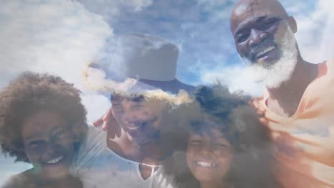 animation of happy african american family embracing at beach over clouds