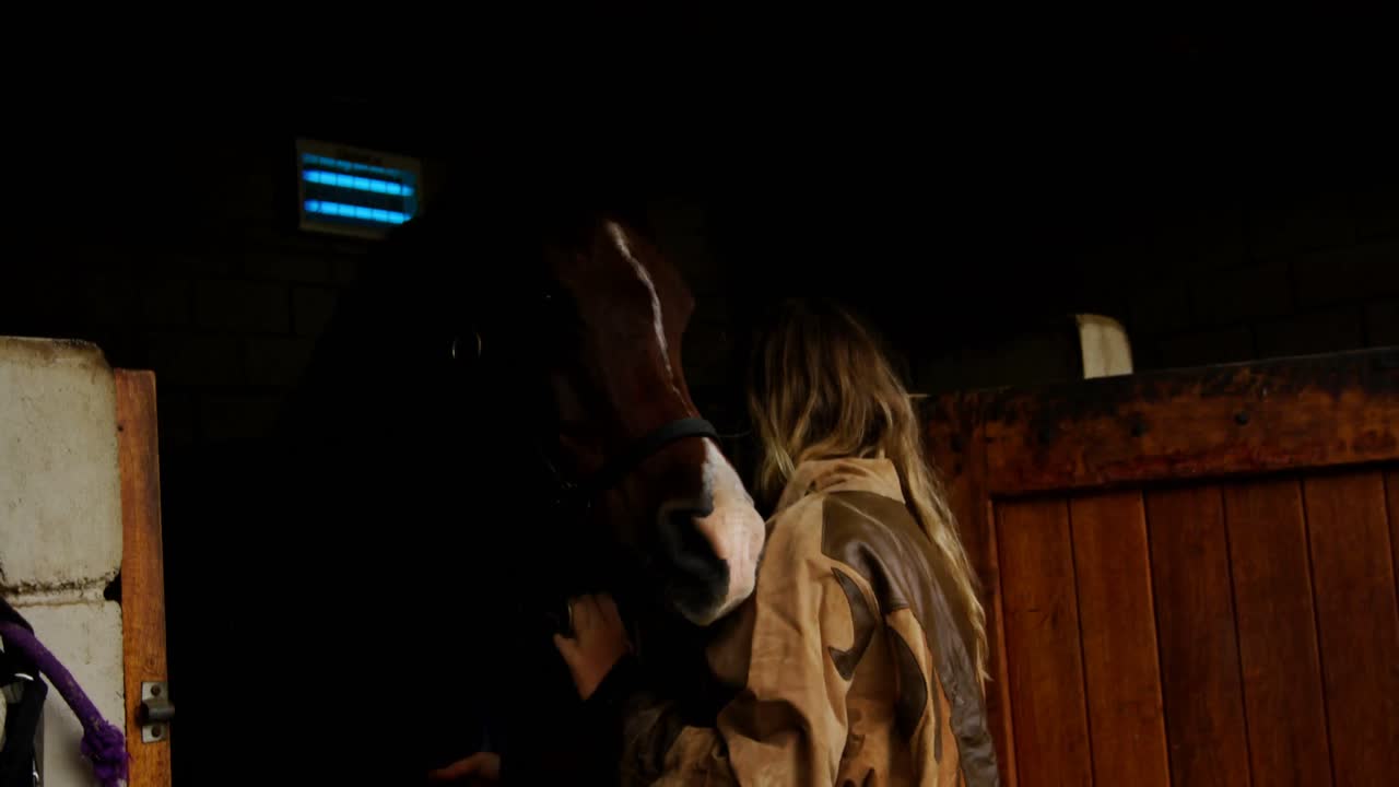 mujer con caballo en el establo 4k