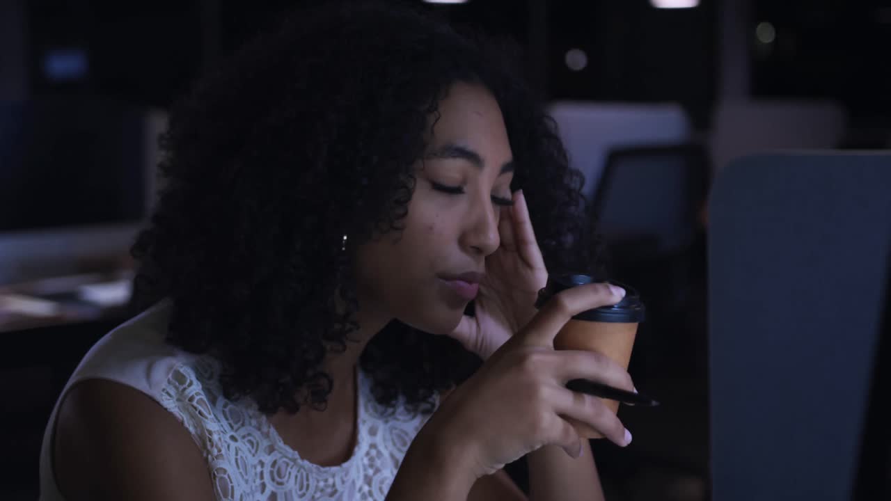 Businesswoman working in a modern office by night