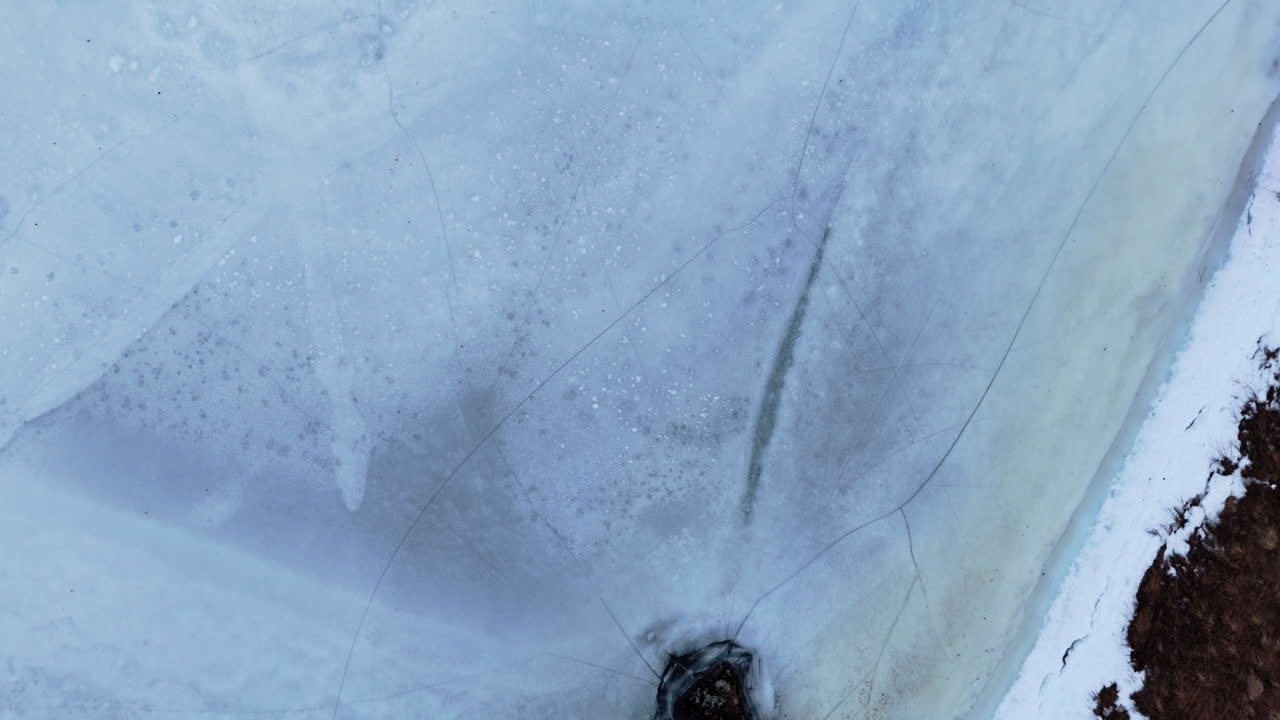 Cracked ice surface with subtle textures, light reflections, and natural patterns