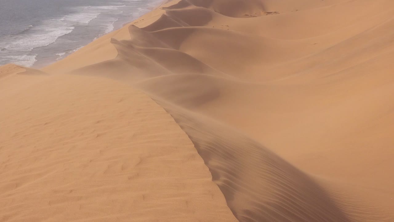 fuertes vientos soplan a través de las asombrosas dunas de arena del desierto de namib a lo largo de la costa esquelética de namibia 5