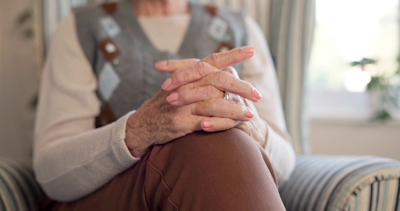 Primo piano delle mani di una donna anziana appoggiate in grembo