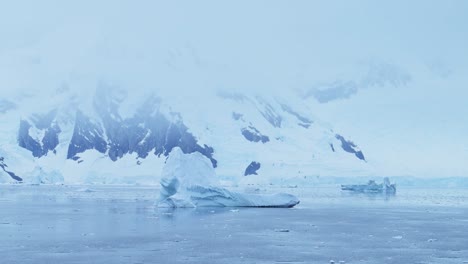 Icebergs-and-Mountains-Scenery-in-Antarctica-Landscape-Scene-with-Big-Dramatic-Ice-Formations,-Global-Warming-and-Climate-Change-on-Coast-with-Ocean-and-Sea-Water-on-Antarctic-Peninsula-in-Winter