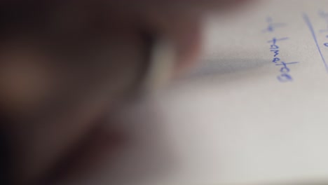 tiro de primer plano extremo de la mano masculina tomando notas en el papel