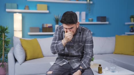 sick young man drinking medicine at home.