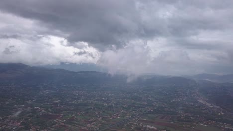 video from above. aerial view of a drone flying through some clouds. italian countryside on background.