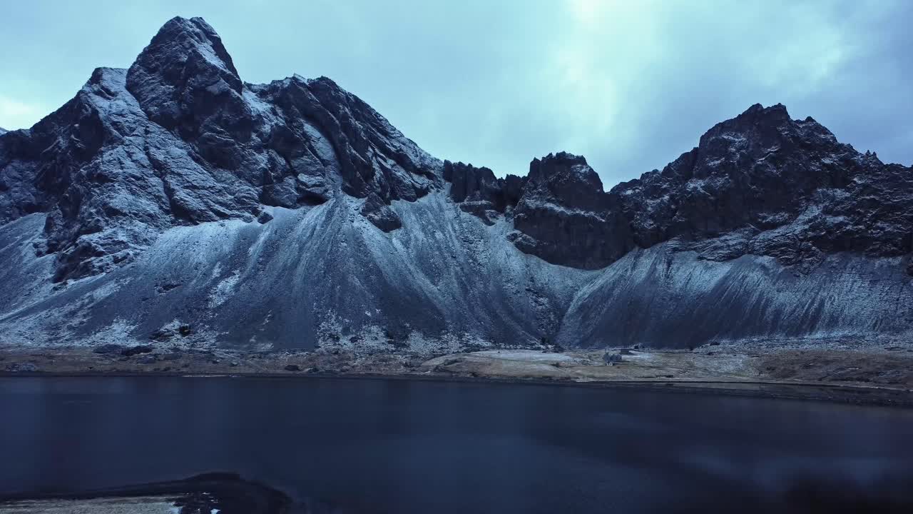 Sneklædte bjerge mod en skyet himmel