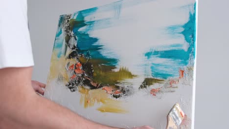 young talented artist working on abstract painting uses paint brush to create picture working in - young talented artist working on abstract painting, uses paint brush to create picture. working in dark creative studio with large canvas and easel. copy space