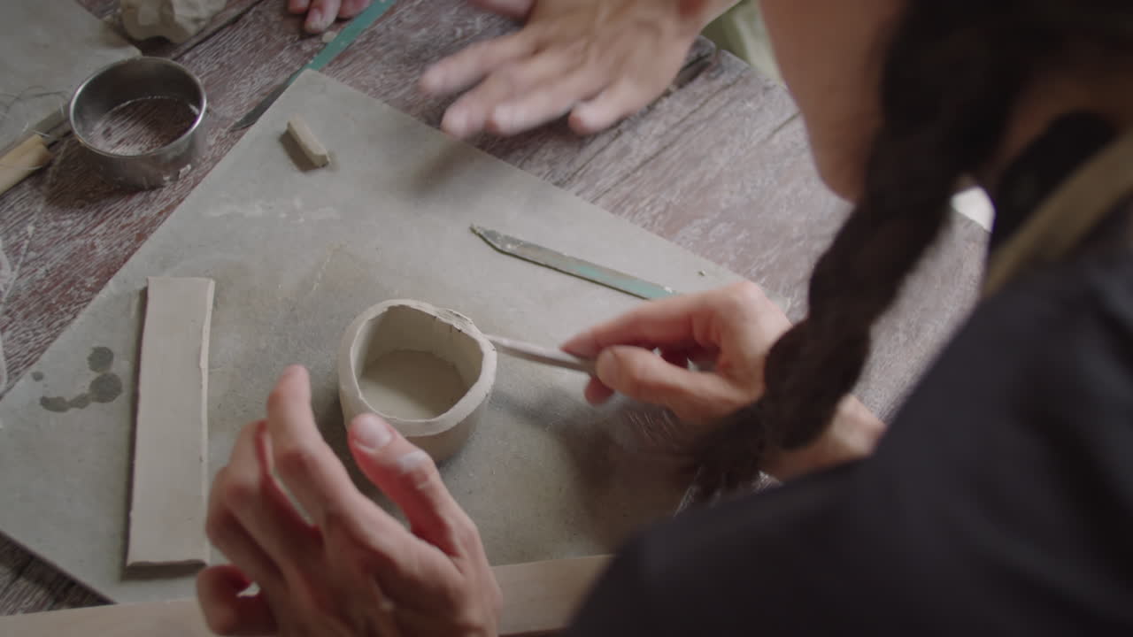 Woman Modeling Clay during Ceramics Workshop