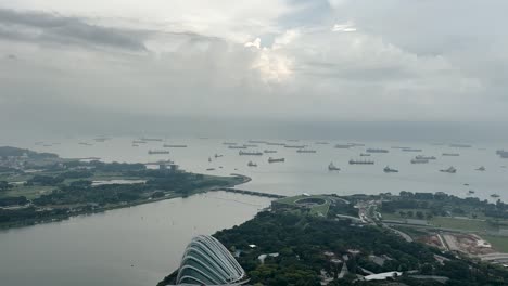 panoramic view of freight ships anchored over strait of singapore coastline