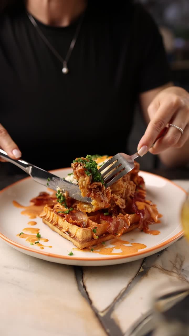 Close-Up of Person Cutting into Delicious Chicken and Waffles