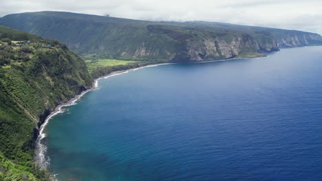 spectacular cliff coastline in waipio bay, aerial flying above ocean, hawaii