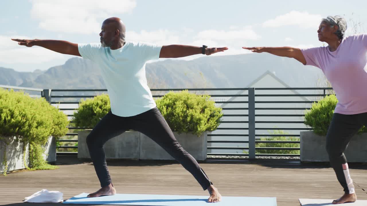 Video of happy african american couple exercise on the terrace