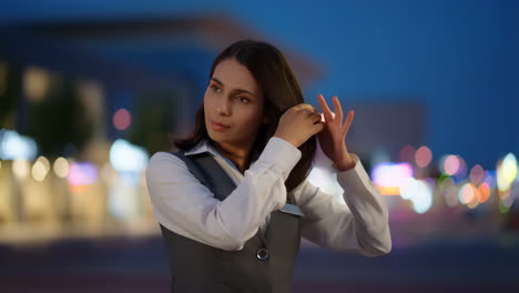 woman adjusting her hair outdoors at night