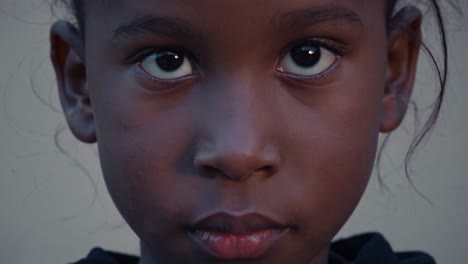 close up portrait showing young african girl with penetrating dark eyes, revealing innate curiosity and pure innocence, symbolizing emerging potential and youthful hope