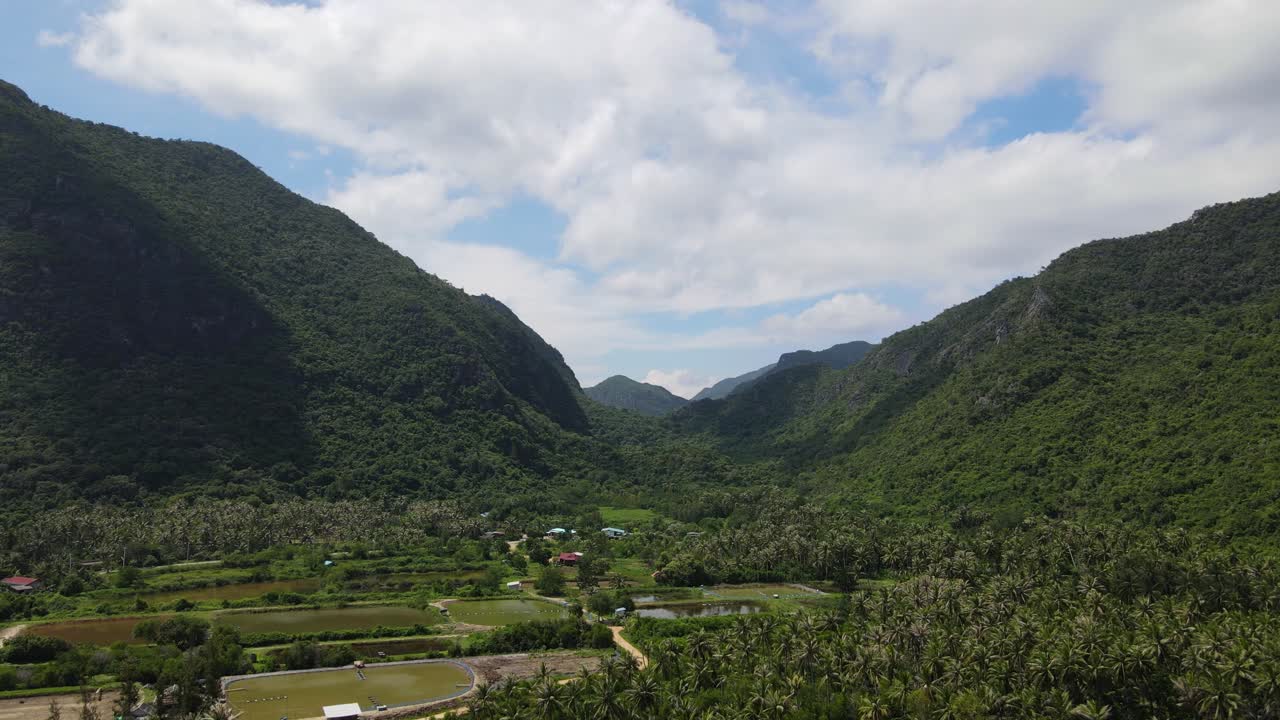 imágenes aéreas hacia un hermoso paisaje entre montañas y cañones, granjas y cocoteros, estanques de peces, parque nacional sam roi yot, prachuap khiri khan, tailandia