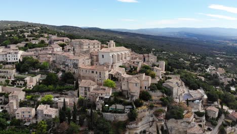 a drone flies around gordes revealing the open valley behind the village