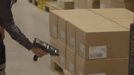 escáner de mano que se utiliza para escanear códigos de barras en cajas en almacenes industriales