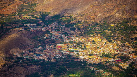 Eine-Luftaufnahme-Von-Wolkenschatten,-Die-Sich-über-Eine-Von-Bergen-Umgebene-Stadtlandschaft-Bewegen