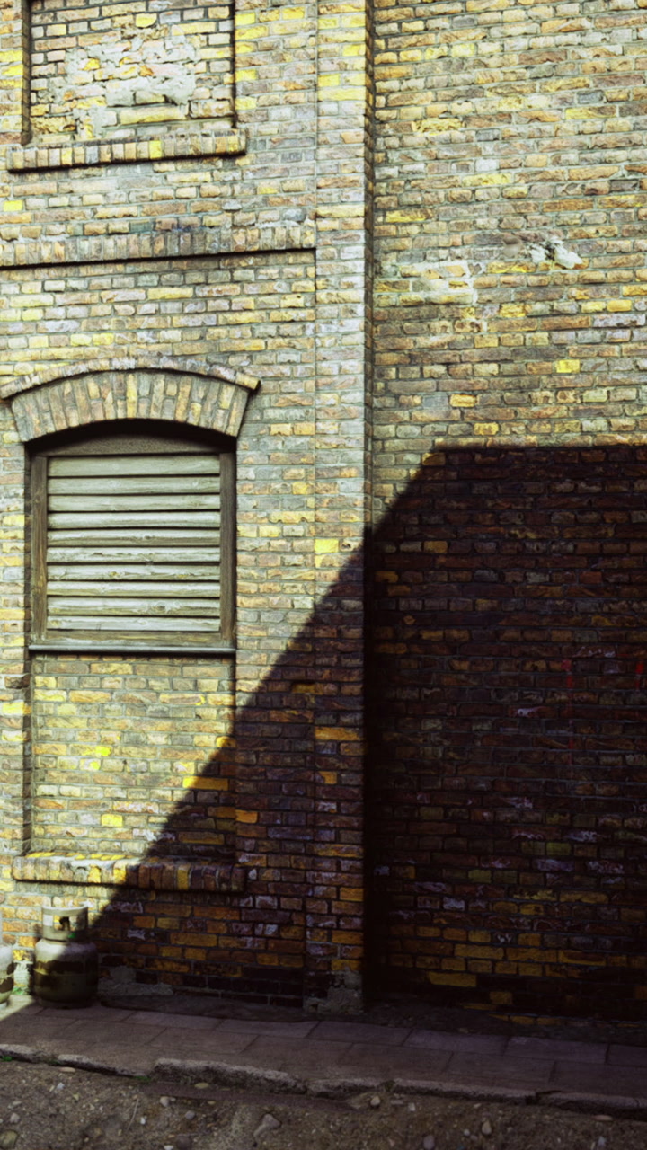 Brick wall casting shadows in a sunlit alley creating a warm atmosphere