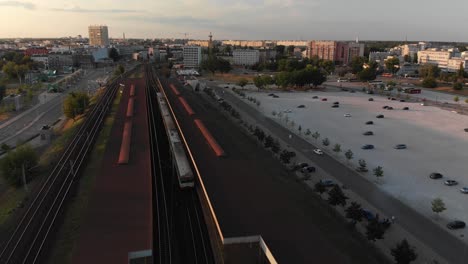 aerial photo of the train entering the city at sunset