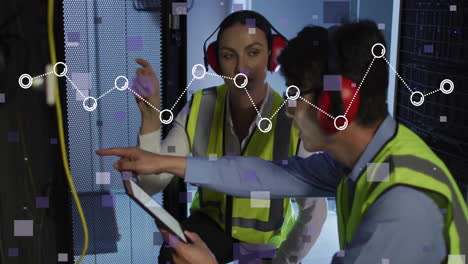 it technicians crouching in server room, examining tablet while displaying digital data overlay