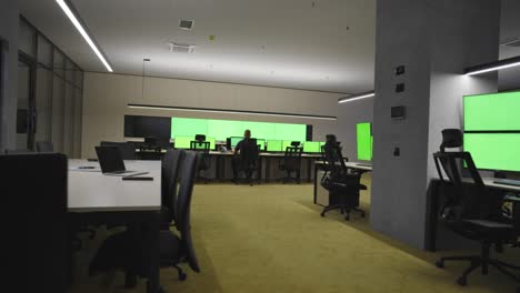 empty office, desk, and chairs at a main cctv security data center with green screen and chroma key