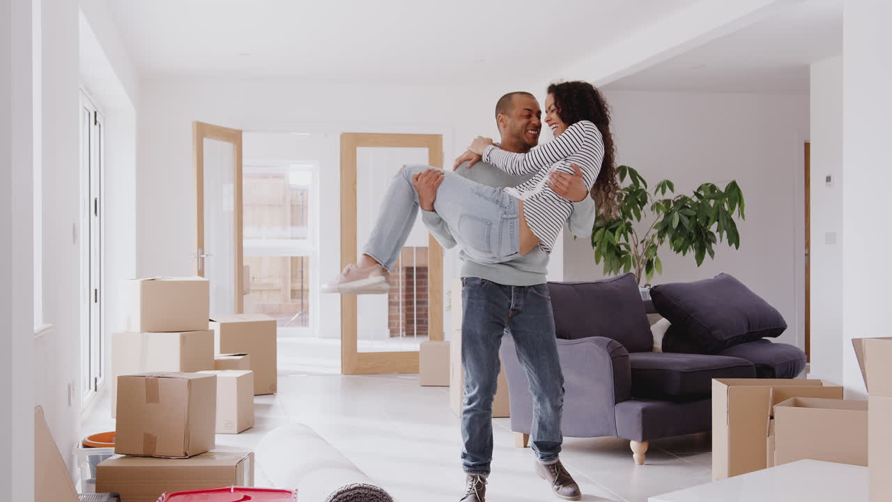 Man Carrying Woman Over Threshold Of New Home On Moving Day